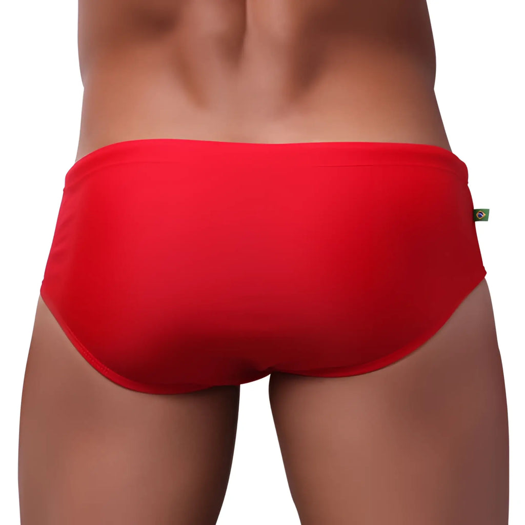 Low rise solids cut sunga male bathing suit in bright red smooth fabric with a small Brazilian flag tag on the side