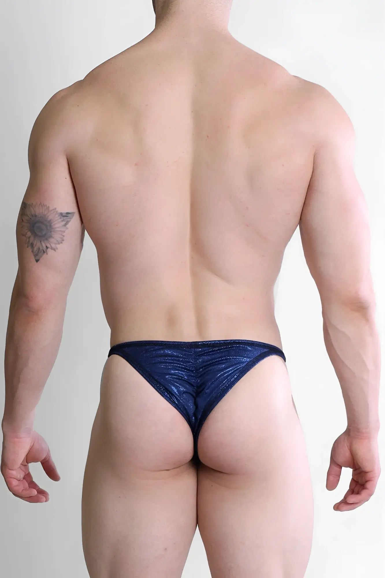Shiny navy blue metallic luna scrunch-butt thong with a ruched design shown from the back side