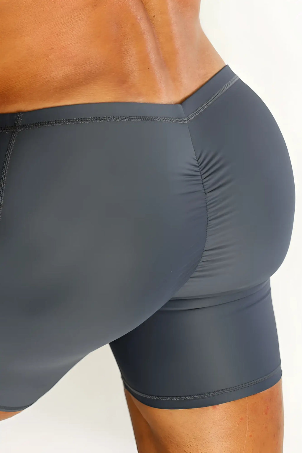 Dark gray form-fitting lustrous scrunch-butt 4.5 inch bike shorts shown from the back with ruched design
