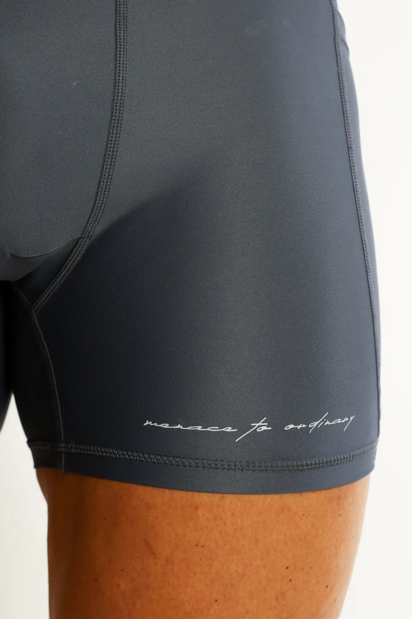 Dark gray lustrous scrunch-butt 4.5 inch bike shorts with sleek form-fitting design and subtle white cursive branding
