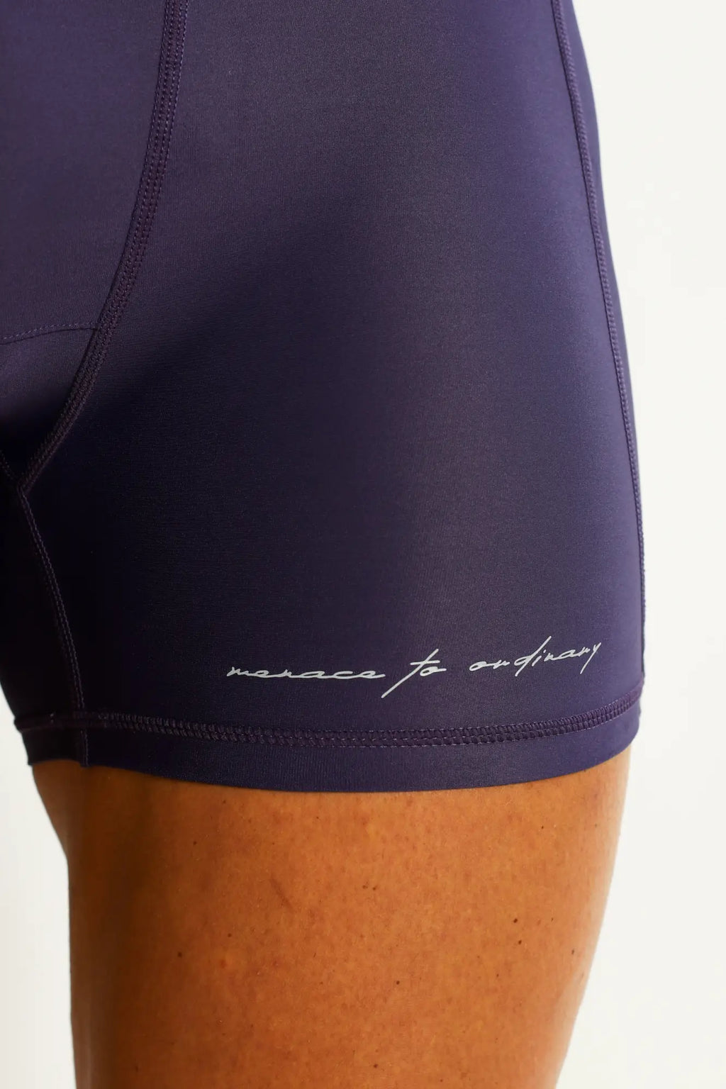 Navy blue high-waisted lustrous scrunch-butt 4.5 inch bike shorts with subtle white cursive logo near hem