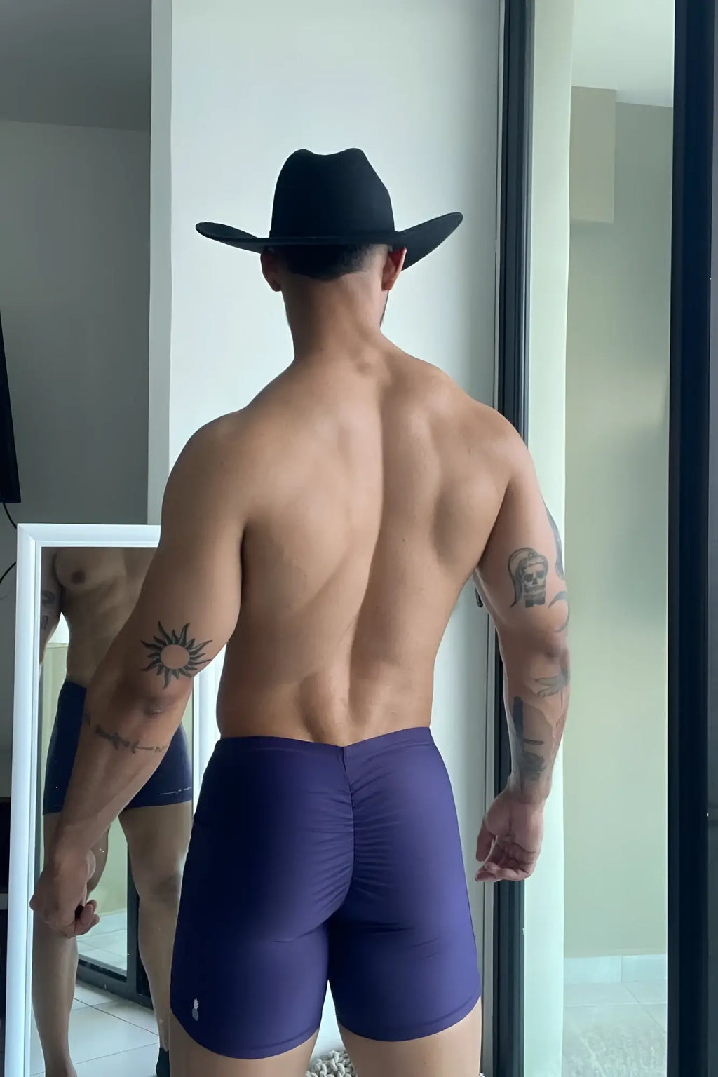 Back view of lustrous scrunch butt 45 inch sugar plum bike shorts with ruching and logo on lower left leg