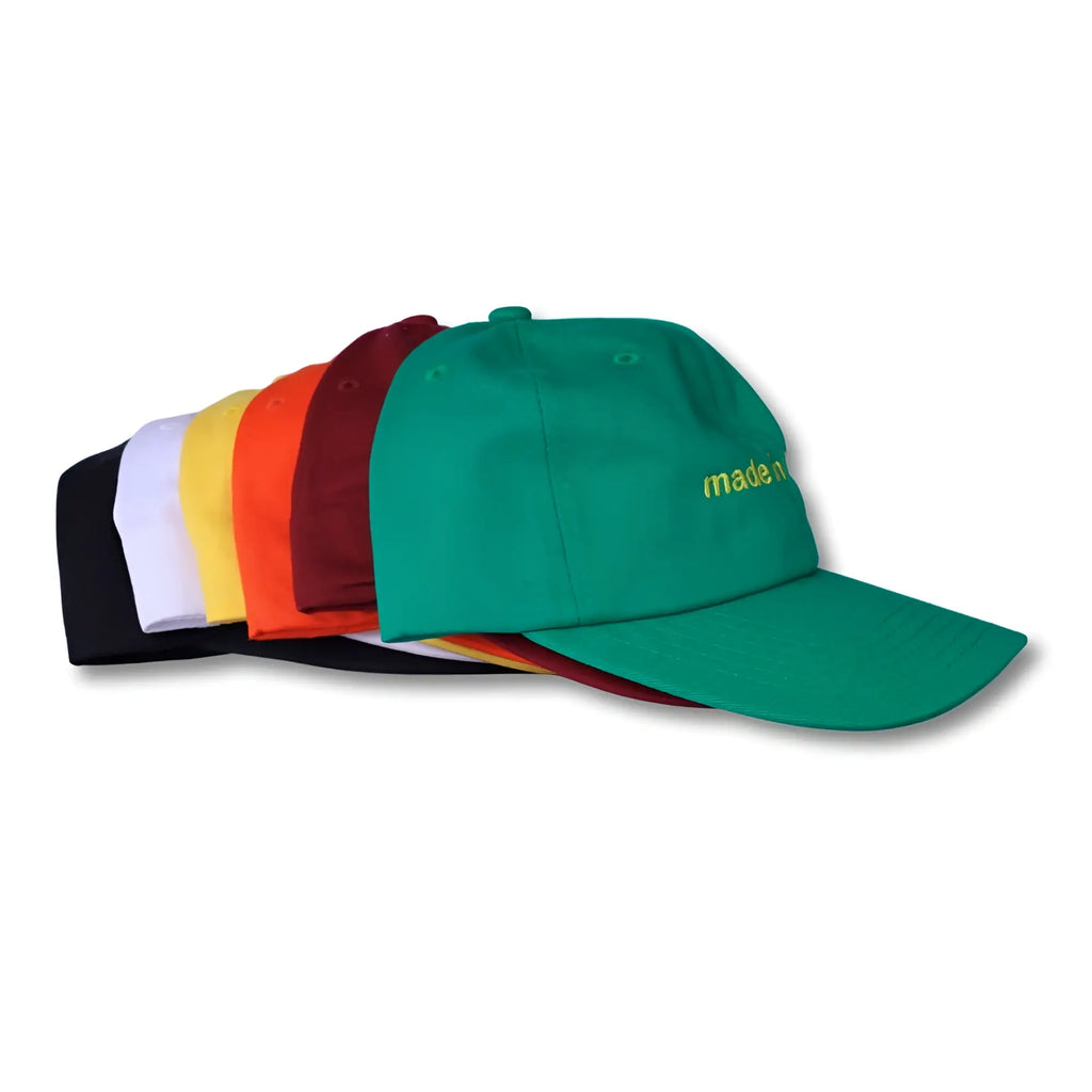 Green dad hat made in Brasil with yellow embroidered text ideal for casual wear and sun protection