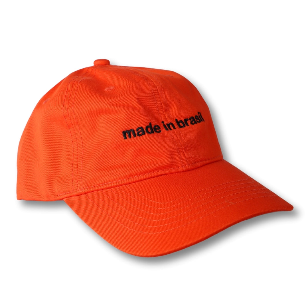 Bright orange dad hat with black embroidered made in brazil text on the front panel