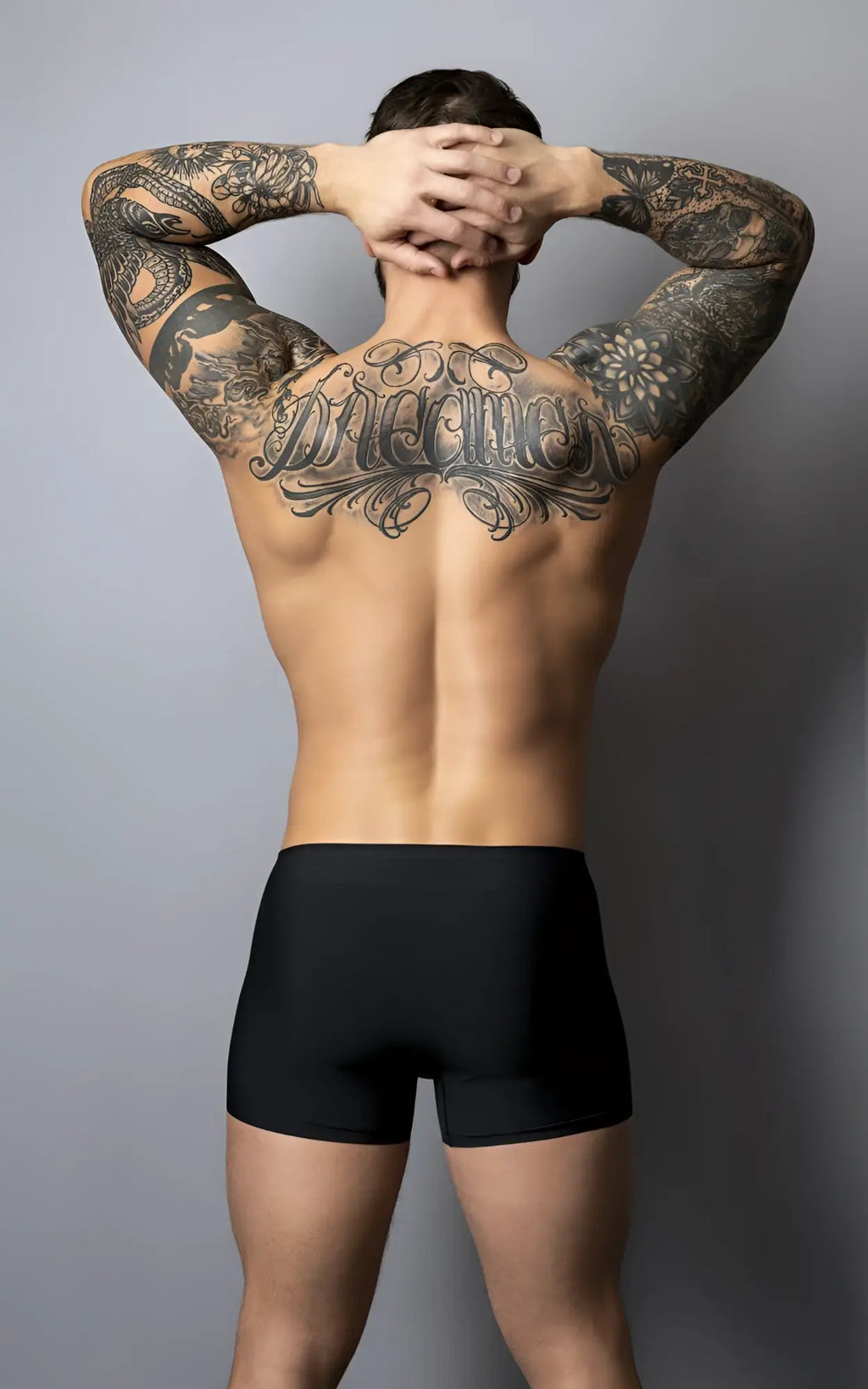 A man showing the back side of male power 154-300 hot mesh pouch short in black red with tattoos and black briefs