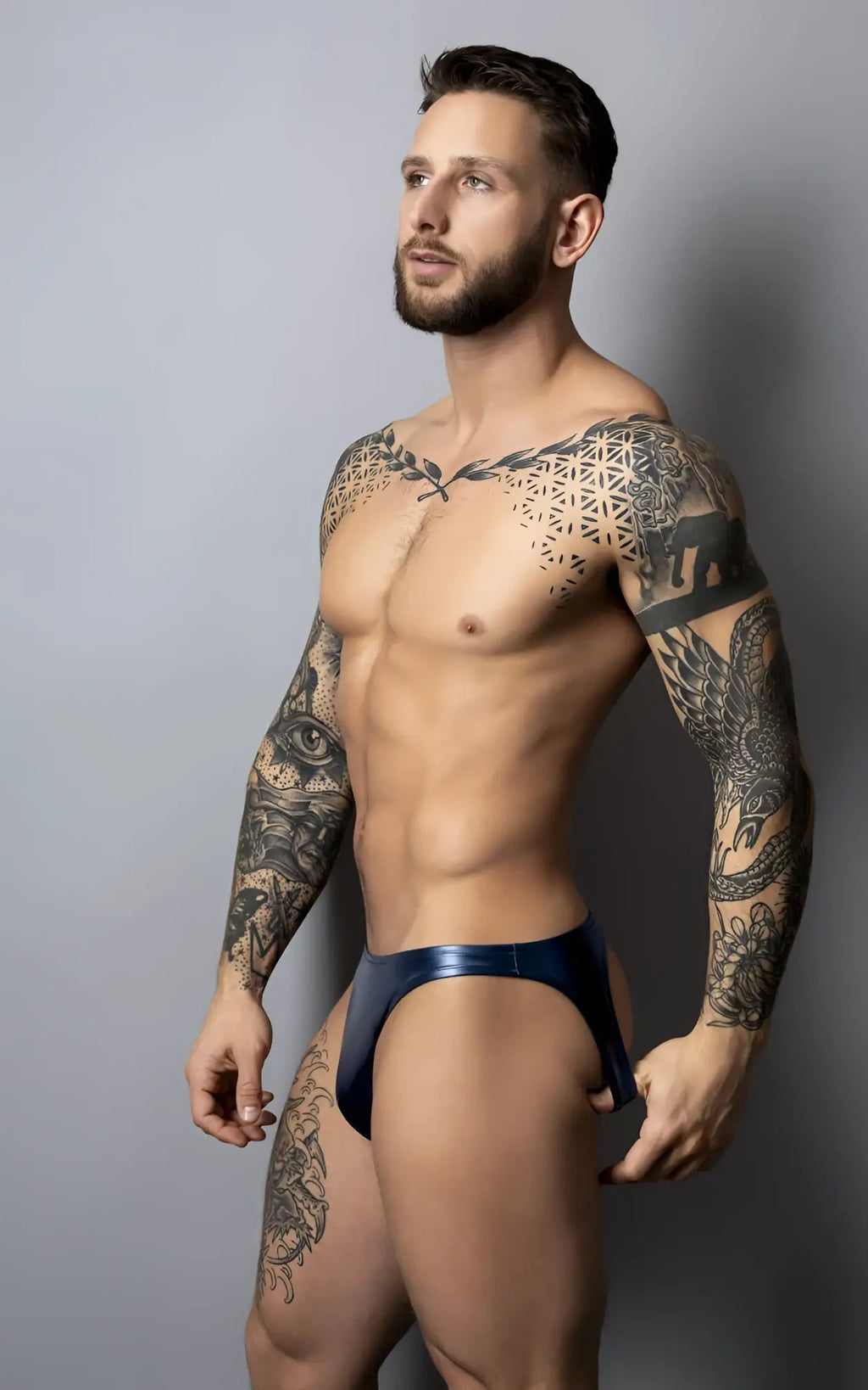 A sleek deep blue metallic brief with a glossy contoured design from male power 300-301 liquid onyx 2.0 moonshine