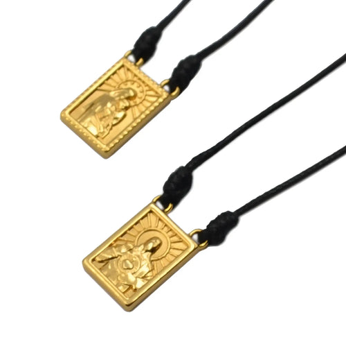 Gold-colored rectangular male scapular pendant with embossed figure and sunburst on black cord men’s necklace
