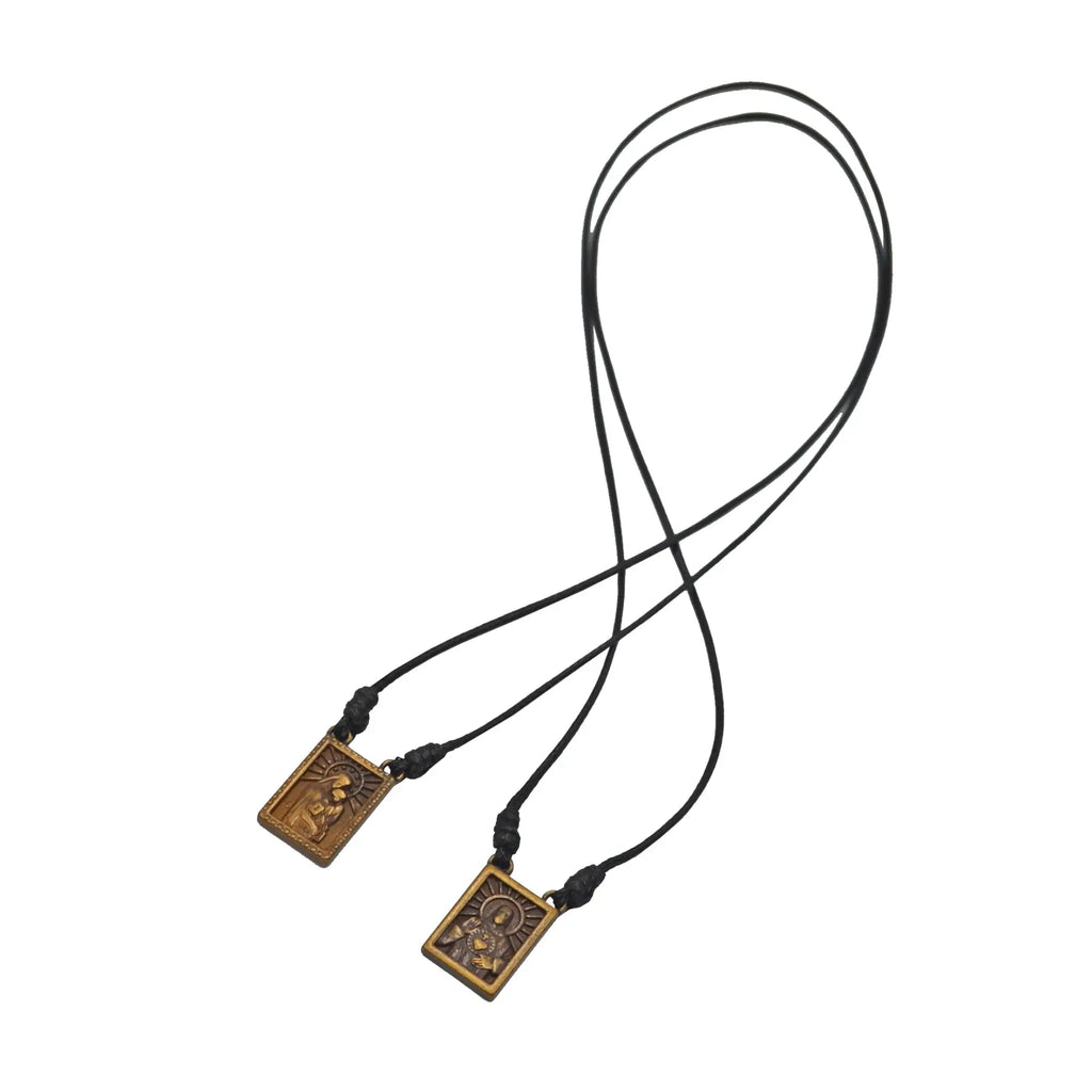 Black cord male scapular necklace with two bronze rectangular pendants engraved with religious imagery