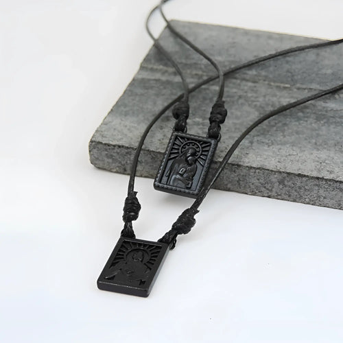 Male scapular with black rectangular pendant featuring engraved religious figure and sunburst design with matte finish