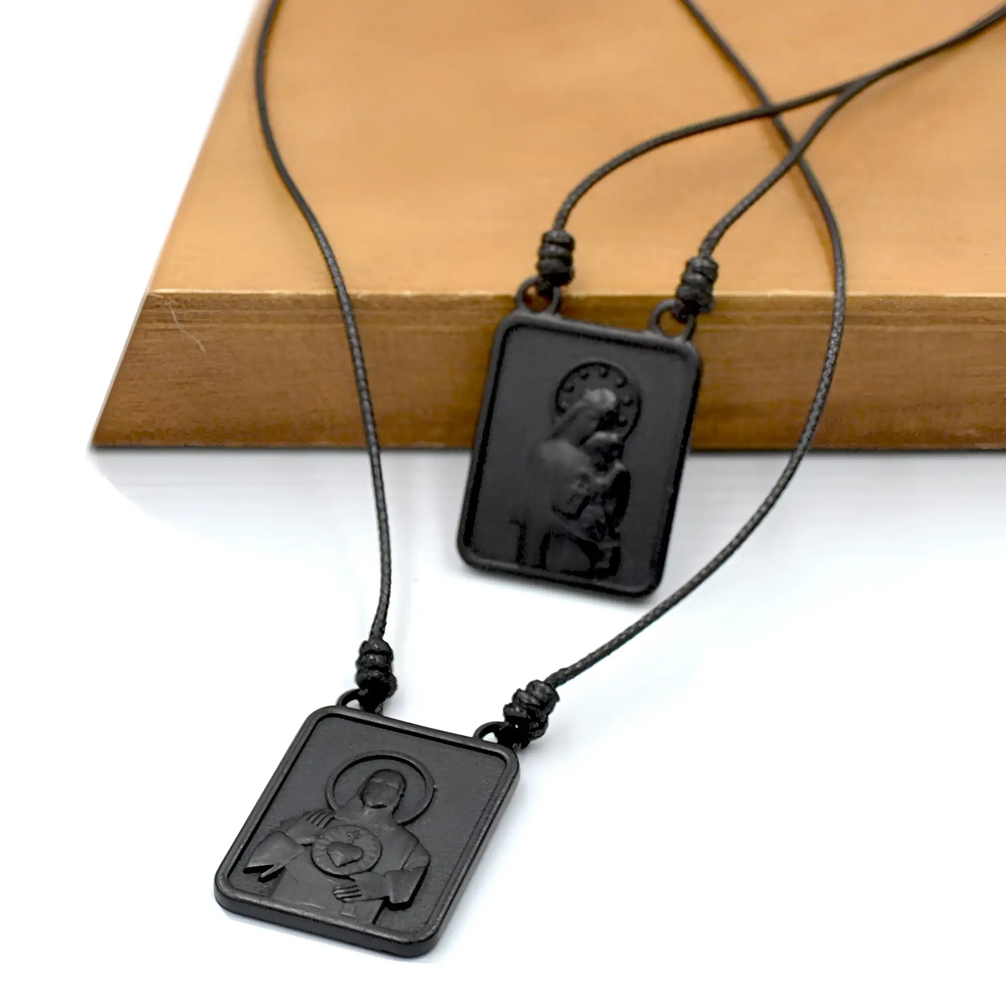 Black rectangular pendant scapular necklace with raised virgin mary and jesus relief on black cord for men