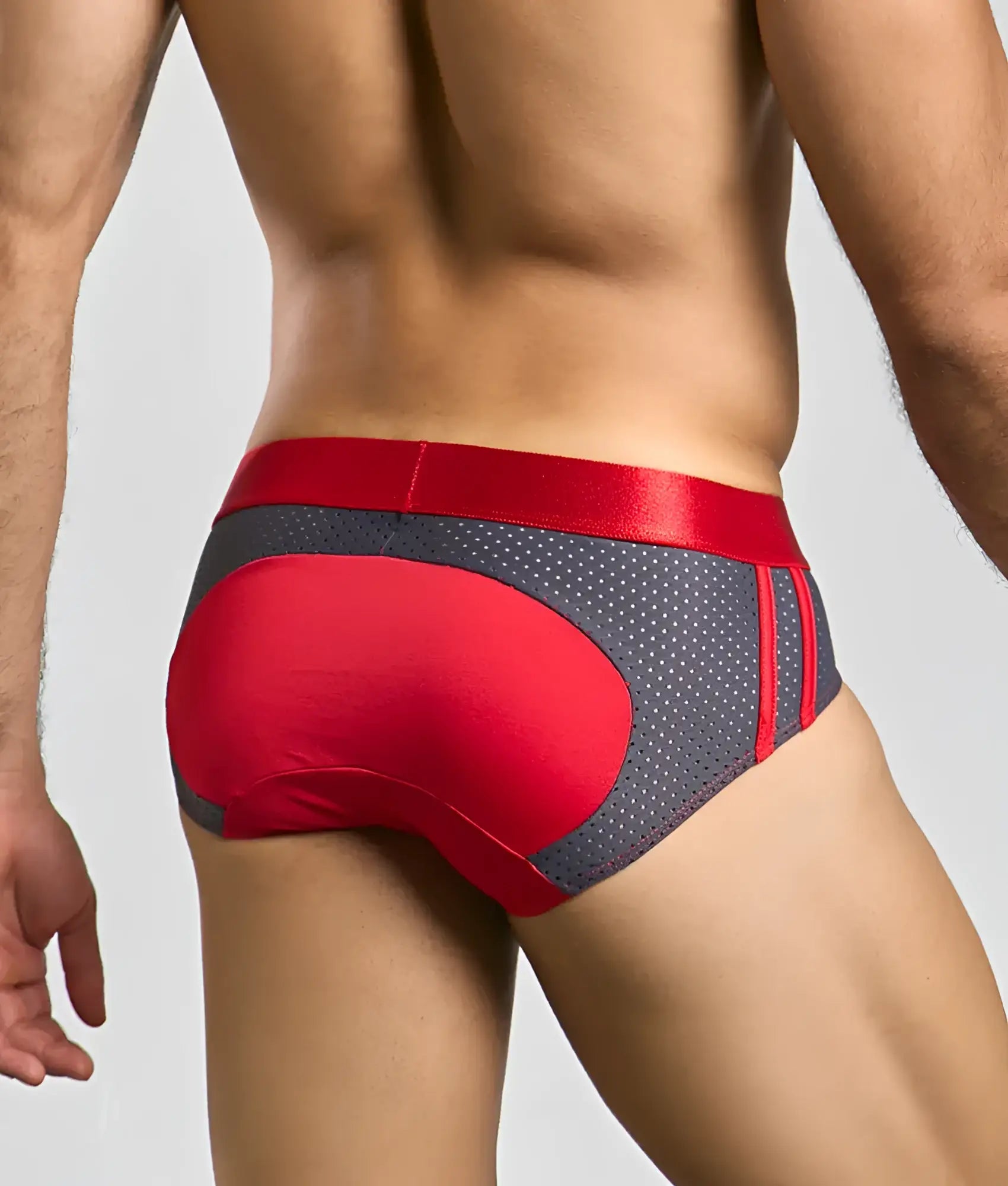 Red and gray male basics spot brief with satin waistband and perforated mesh panels for athletic wear