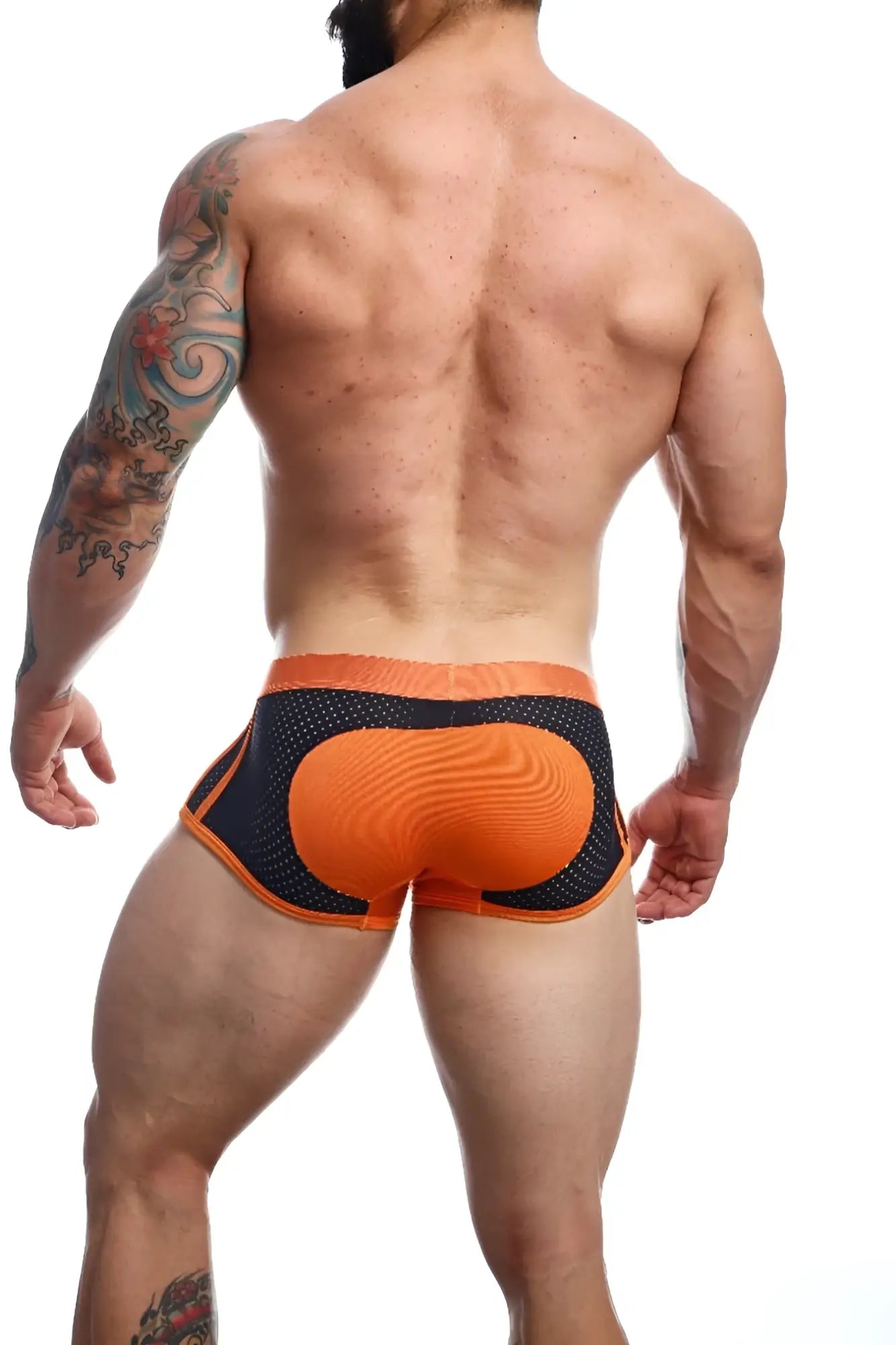 Back side of malebasics spot new sexier trunk pink mesh briefs with textured padded orange panel and black mesh