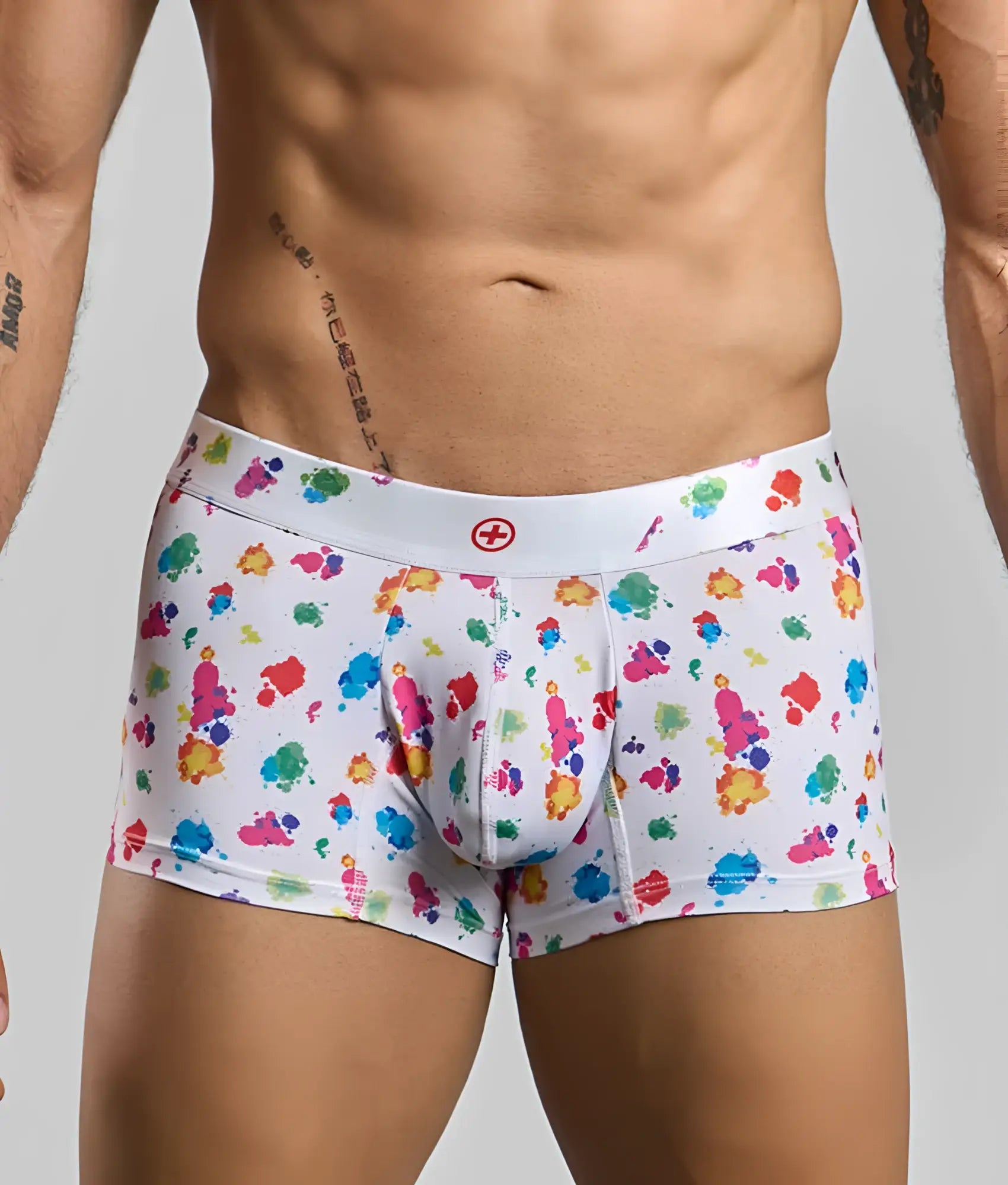 White boxer briefs with vibrant multicolored paint splatter pattern and red cross logo on waistband malebasics trunk hipster white splash