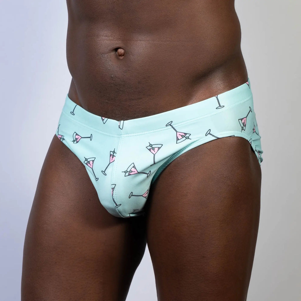 Mint green swim brief with playful pink martini glass pattern designed for stylish beachwear and pool use
