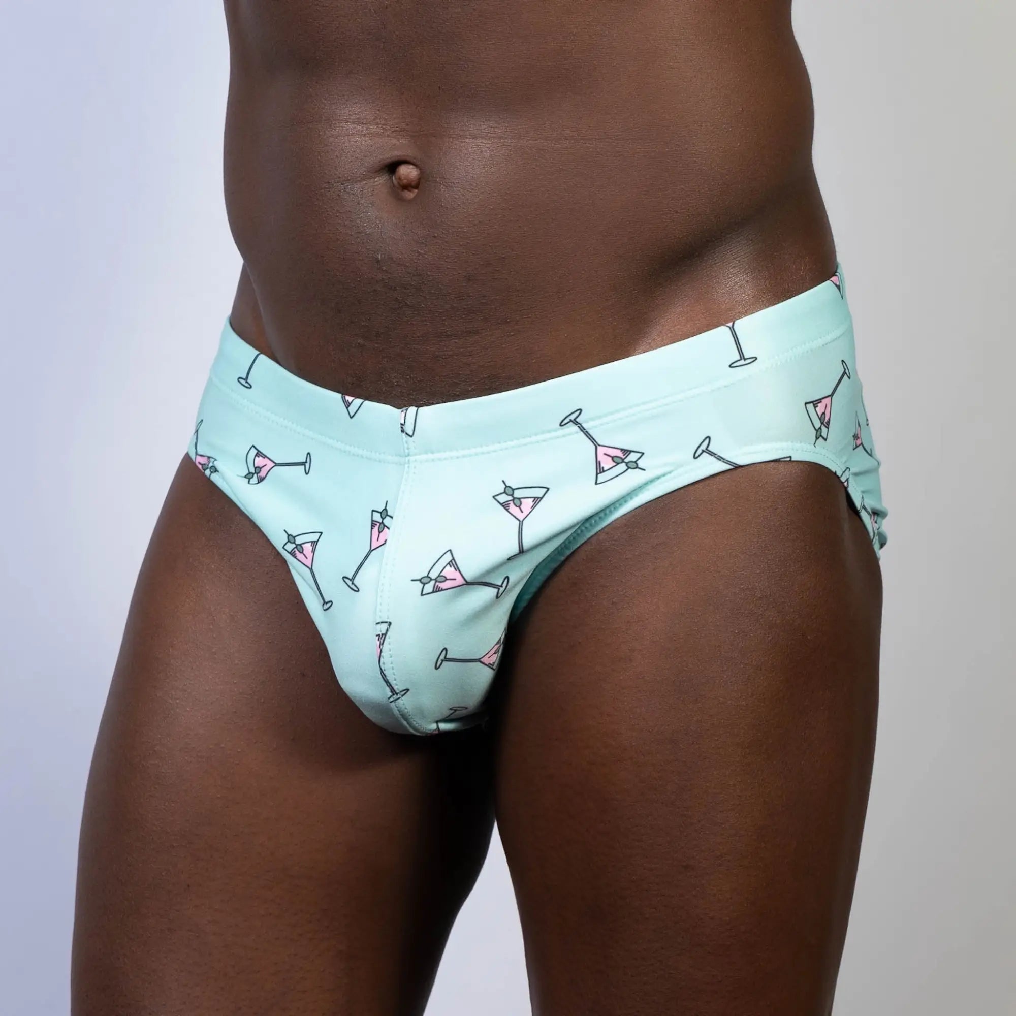 Mint green swim brief with playful pink martini glass pattern designed for stylish beachwear and pool use