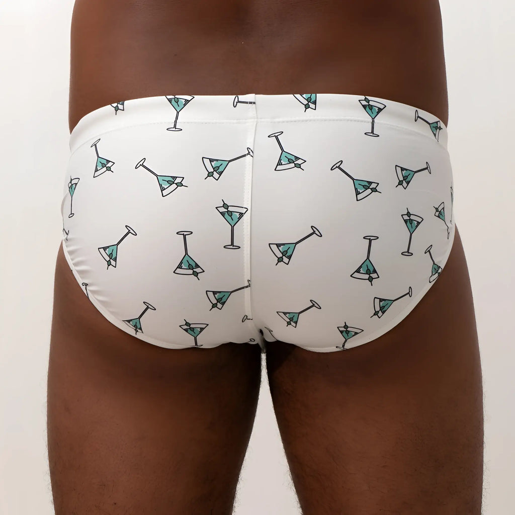 White swim trunks with teal martini glass pattern and black outlines from martini swim brief collection