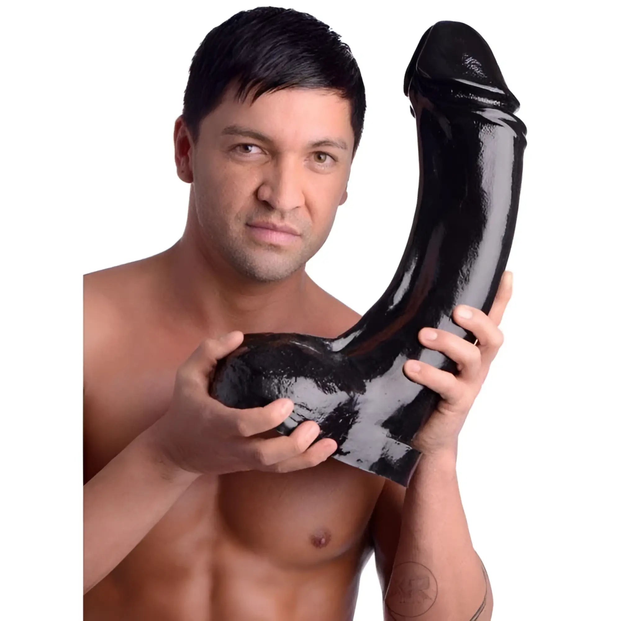 A shirtless man holding a large, black, XXXL Master Cock The Annihilator dildo against a white background.