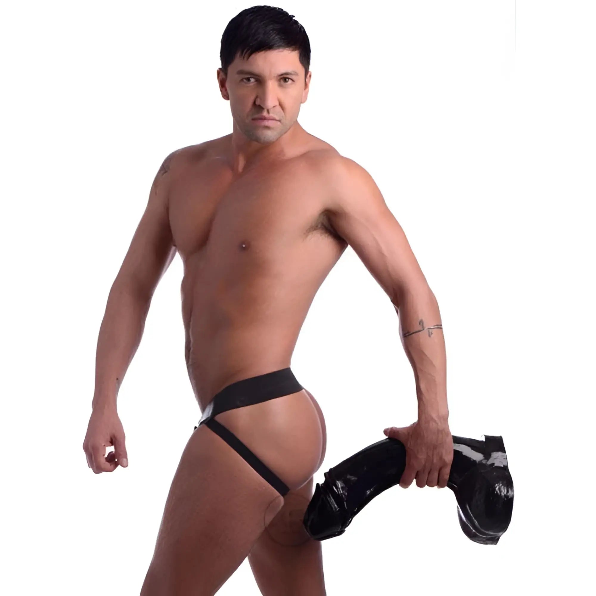 A man wearing a black jockstrap holding a large, black, realistic XXXL Master Cock Annihilator dildo.