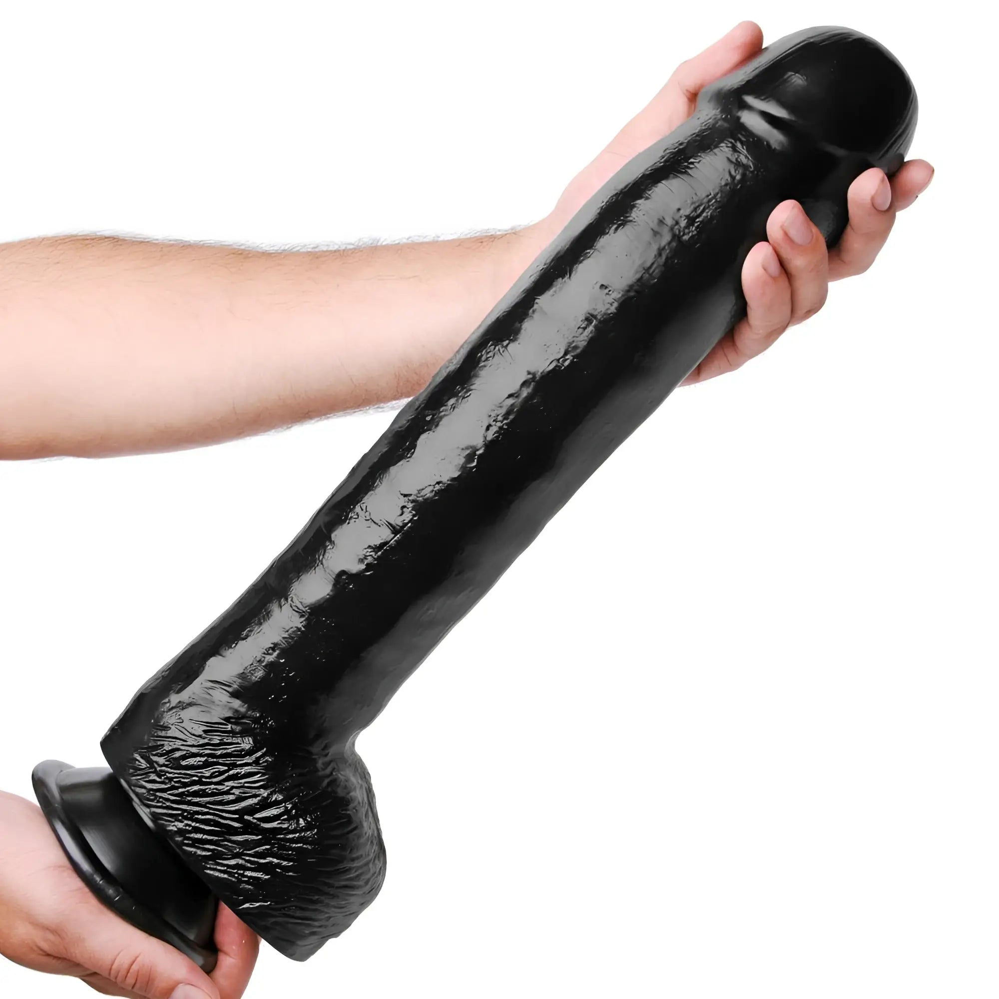 A person holds the black, textured Master Cock The Black Destroyer, a large, realistic-style dildo with a suction base.