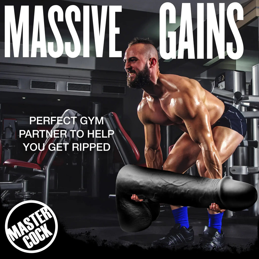 A muscular man lifting a huge, black, two-foot-tall Master Cock Moby dildo as a weight in a gym setting.