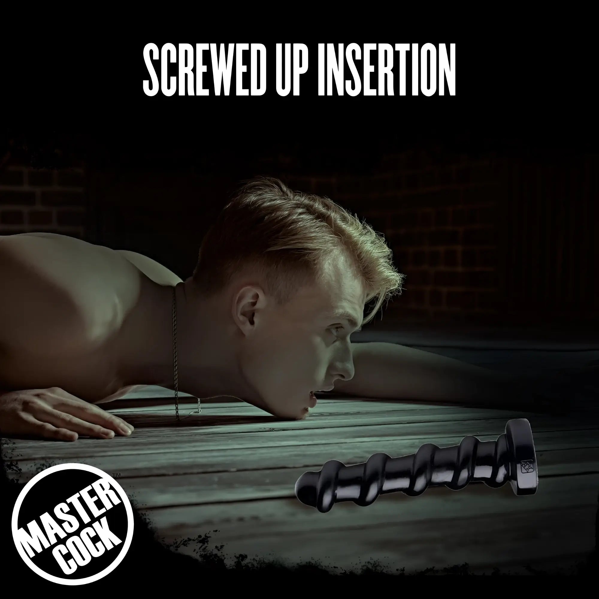 Master Cock Screw Dildo: A black, spiral-shaped dildo resting on a wooden floor near a man in a moody, dark setting.