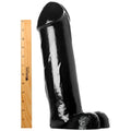 Master Cock The Titan: A large black dildo standing next to a 12-inch wooden ruler for scale on a white background.