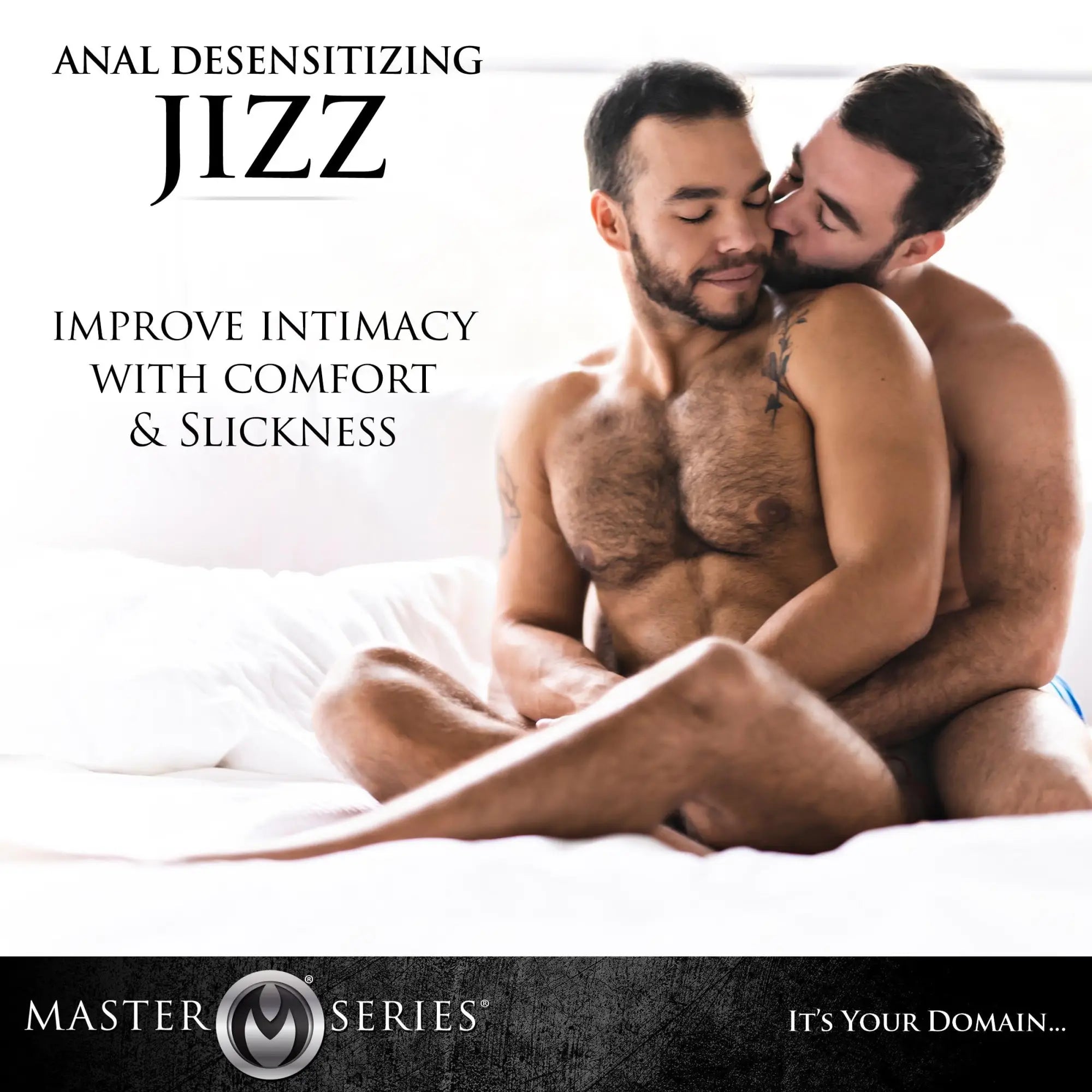 Two shirtless men cuddling on a bed. Text advertises Master Series 8.5oz Jizz Scented Desensitizing Lube.