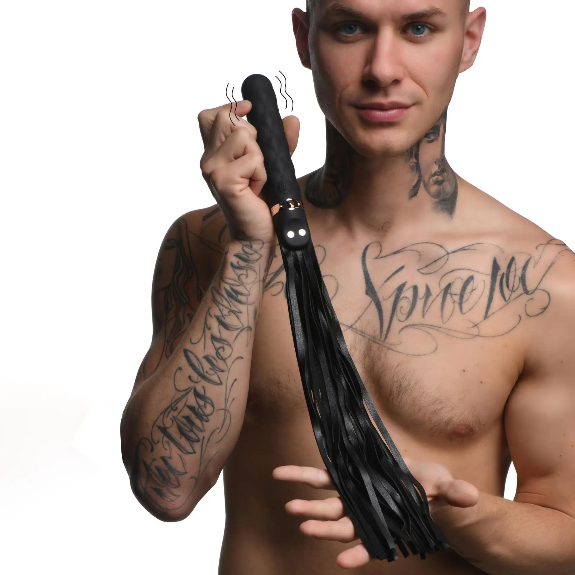 A tattooed man holds a black silicone Master Series 9X vibrating flogger with rose gold accents and hanging strips.
