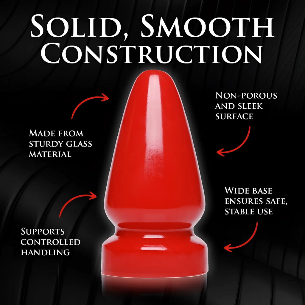 Master Series The Anal Destructor, a glossy red, smooth glass butt plug with a wide base on a black background.
