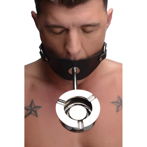 Master Series Ashtray Ball Gag: A shirtless man wears a black leather collar connected to a stainless steel ashtray.