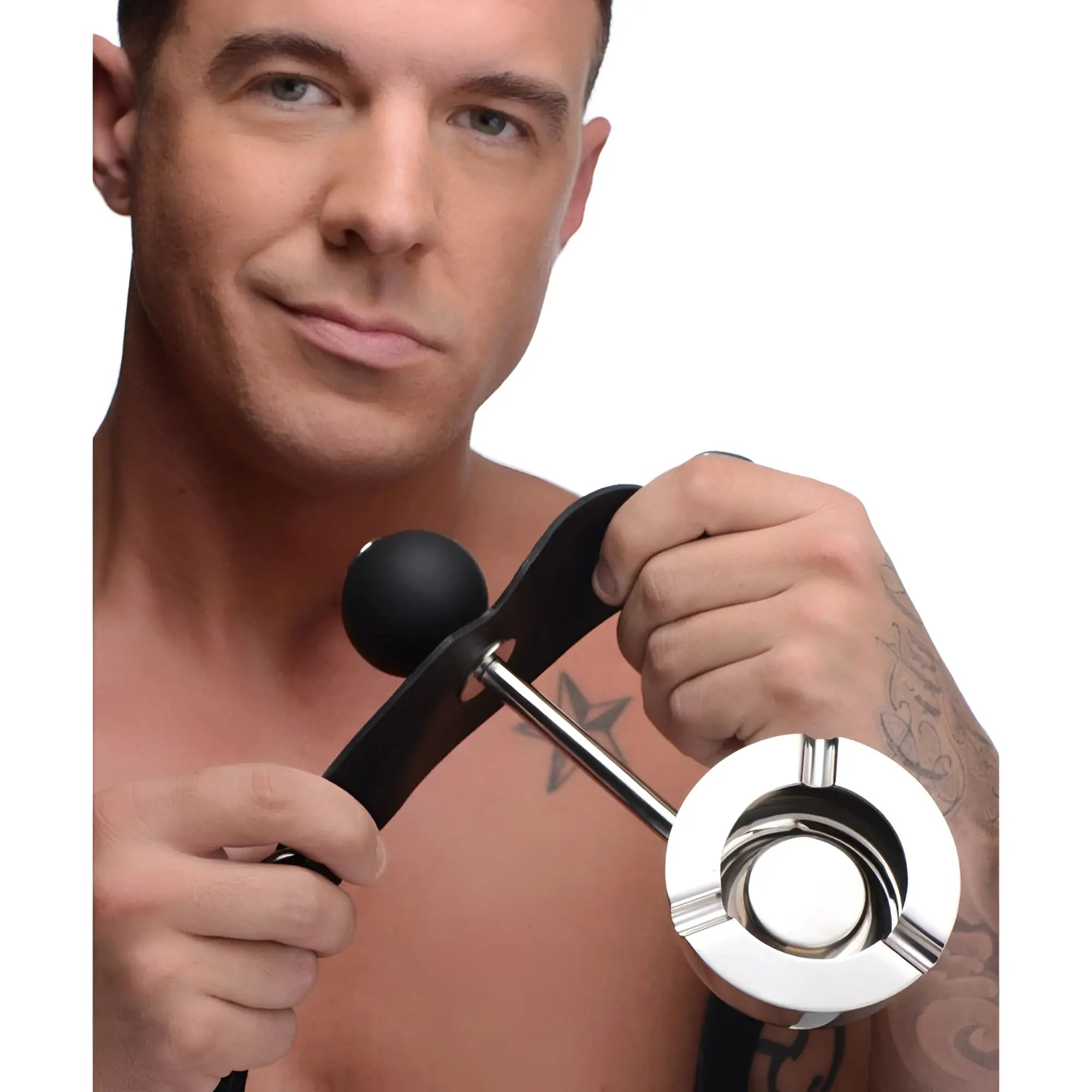 A man holds a Master Series Ashtray Ball Gag, featuring a black silicone sphere on a leather strap and silver ashtray.