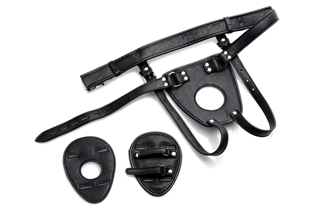 Master Series black faux-leather anal harness with adjustable waist belt and two interchangeable shield attachments.