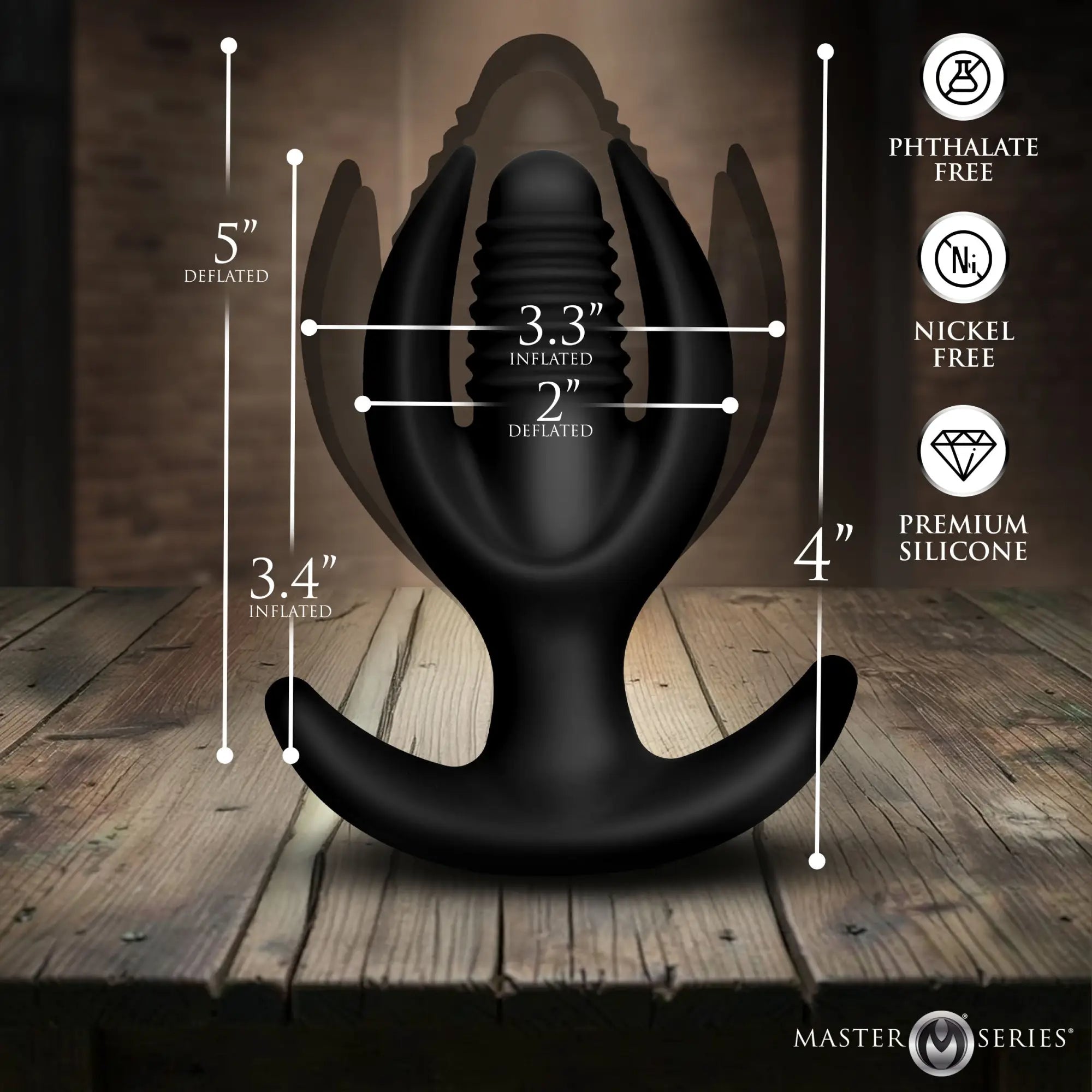 Black Master Series inflatable silicone anal plug with anchor-shaped base and measurement callouts on wooden table.
