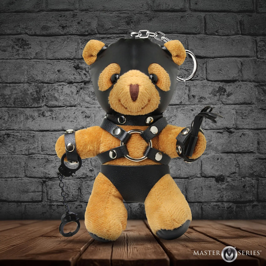 Master Series Master Bear keychain: brown plush bear in black leather hood, harness, and shorts, holding a whip and cuffs.