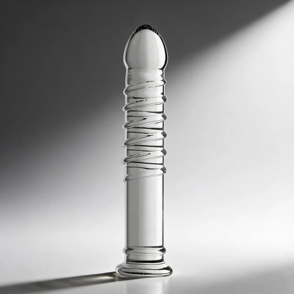 Master Series Behemoth XL dildo, a clear glass toy featuring a rounded tip, spiraled ribs, and a flared base.
