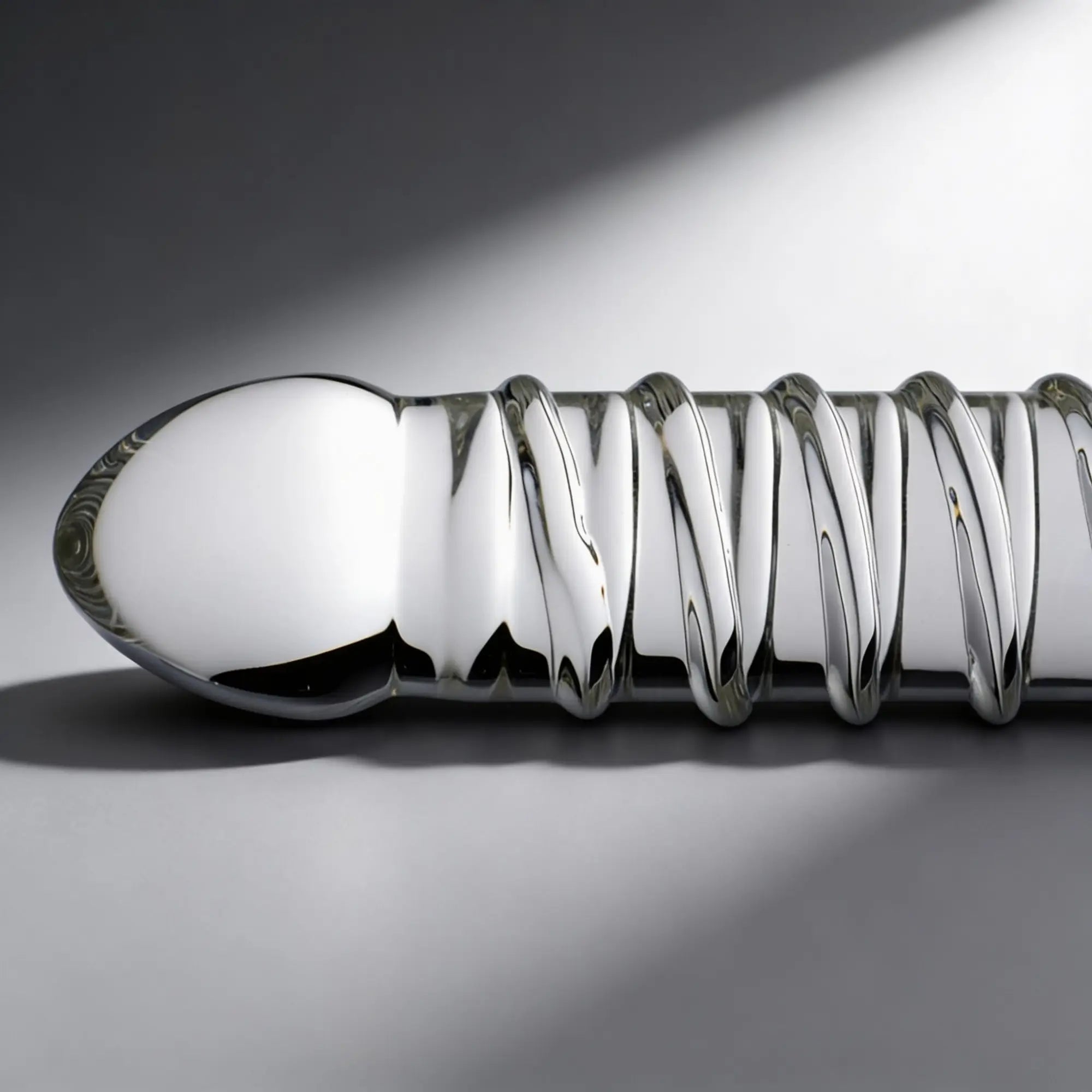 Master Series Behemoth XL dildo, a smooth, silver, metallic-finish toy with a prominent, spiraling ribbed texture.