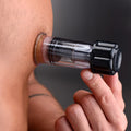Master Series Black Maxxx Twist Nipple Sucker: A clear plastic cylinder device attached to skin via a black dial.
