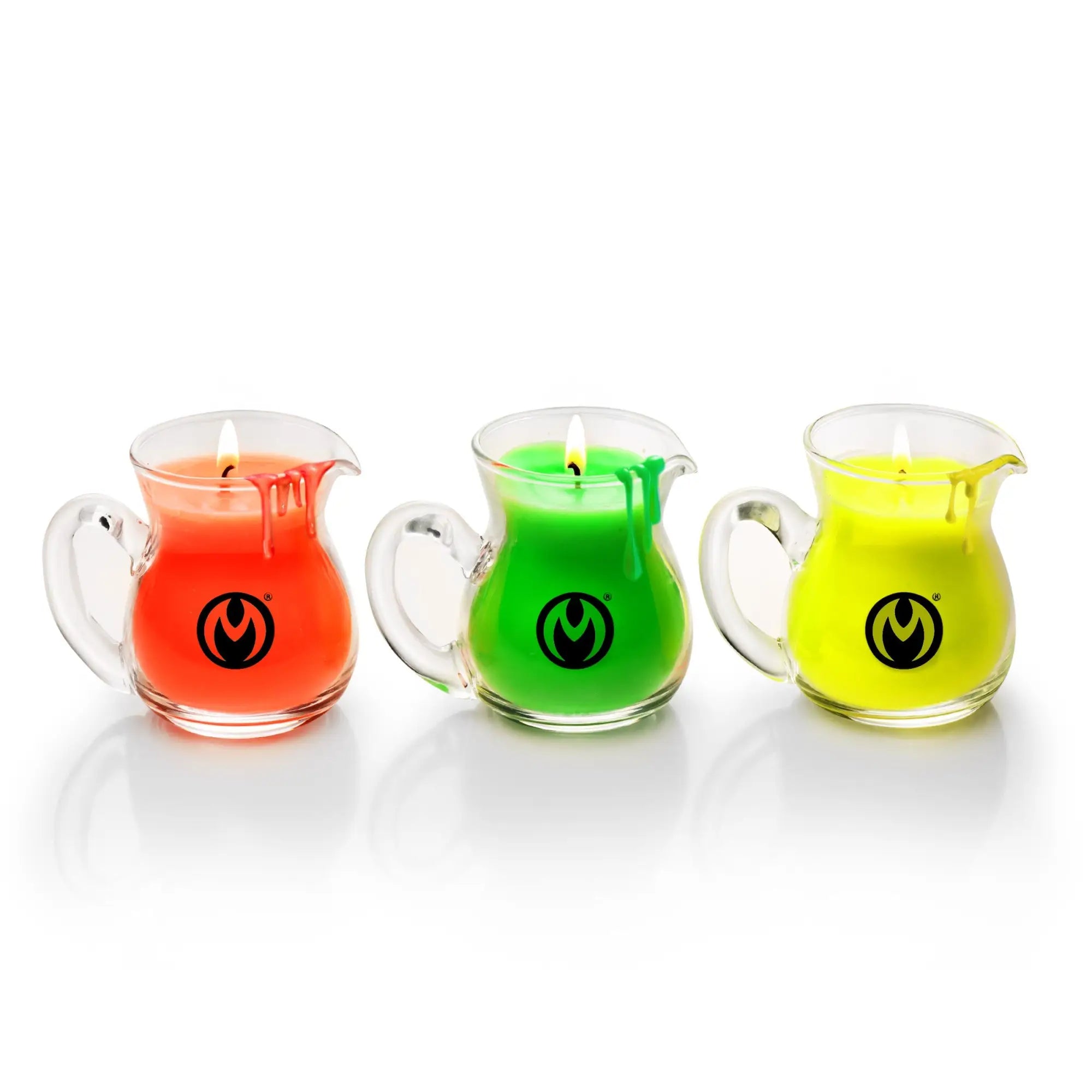 Three Master Series Blacklight Wax Play Pitchers in orange, green, and yellow with lit wicks in glass pitchers.