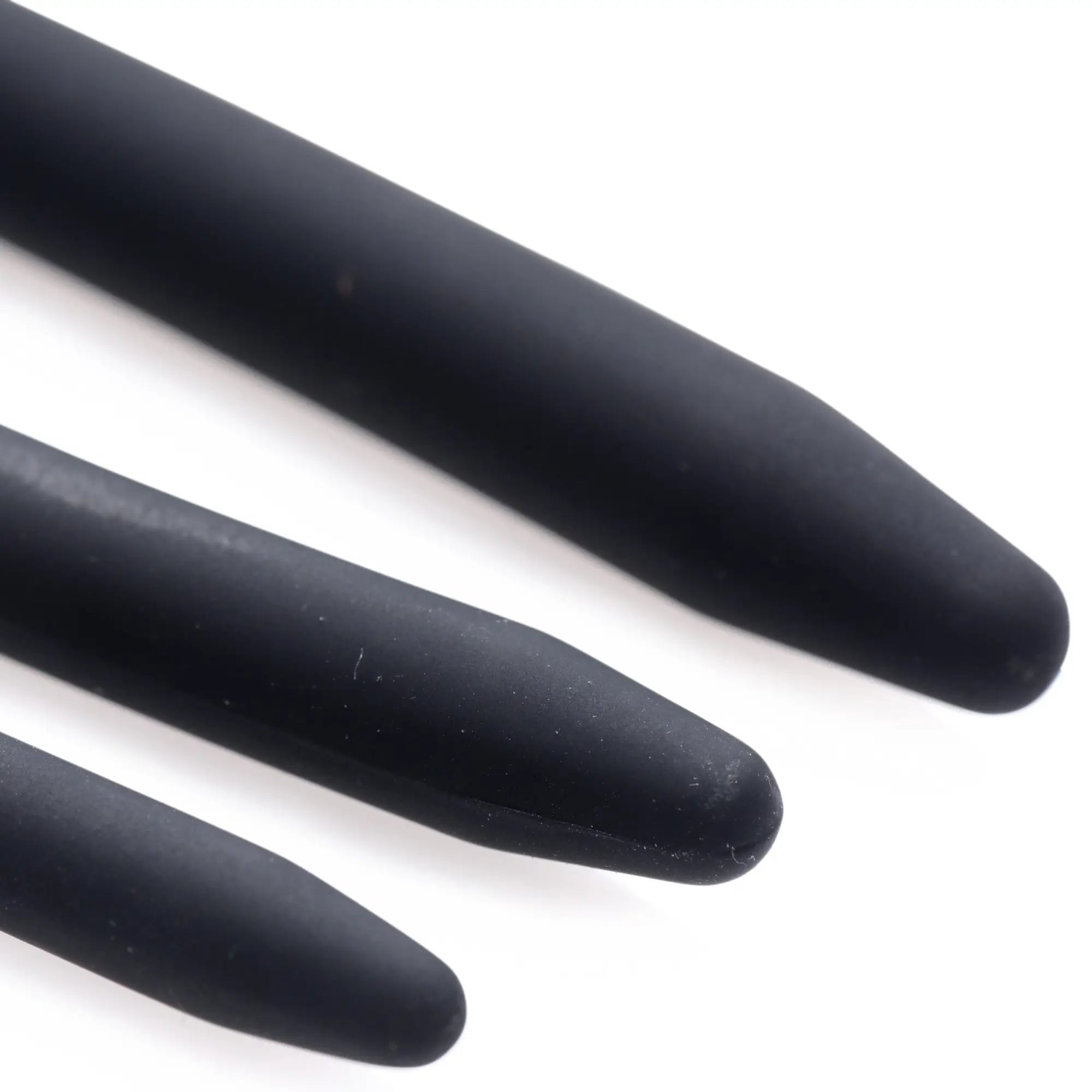 Close-up of three matte black Master Series Bolted Deluxe silicone urethral sounds with tapered, rounded tips.