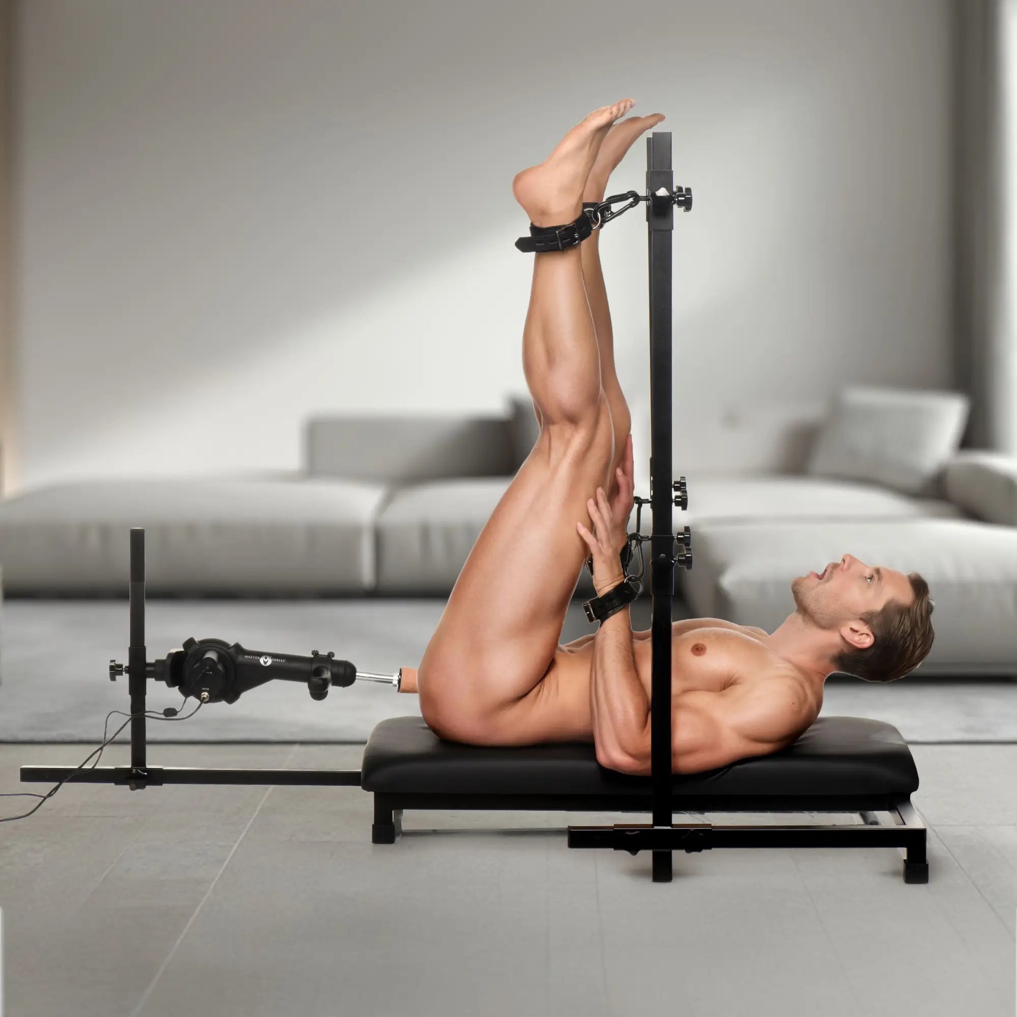 Master Series Breed Master Breeding Stand with black metal frame, integrated sex machine, and leather ankle cuffs.