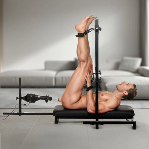 Master Series Breed Master Breeding Stand with black metal frame, integrated sex machine, and leather ankle cuffs.