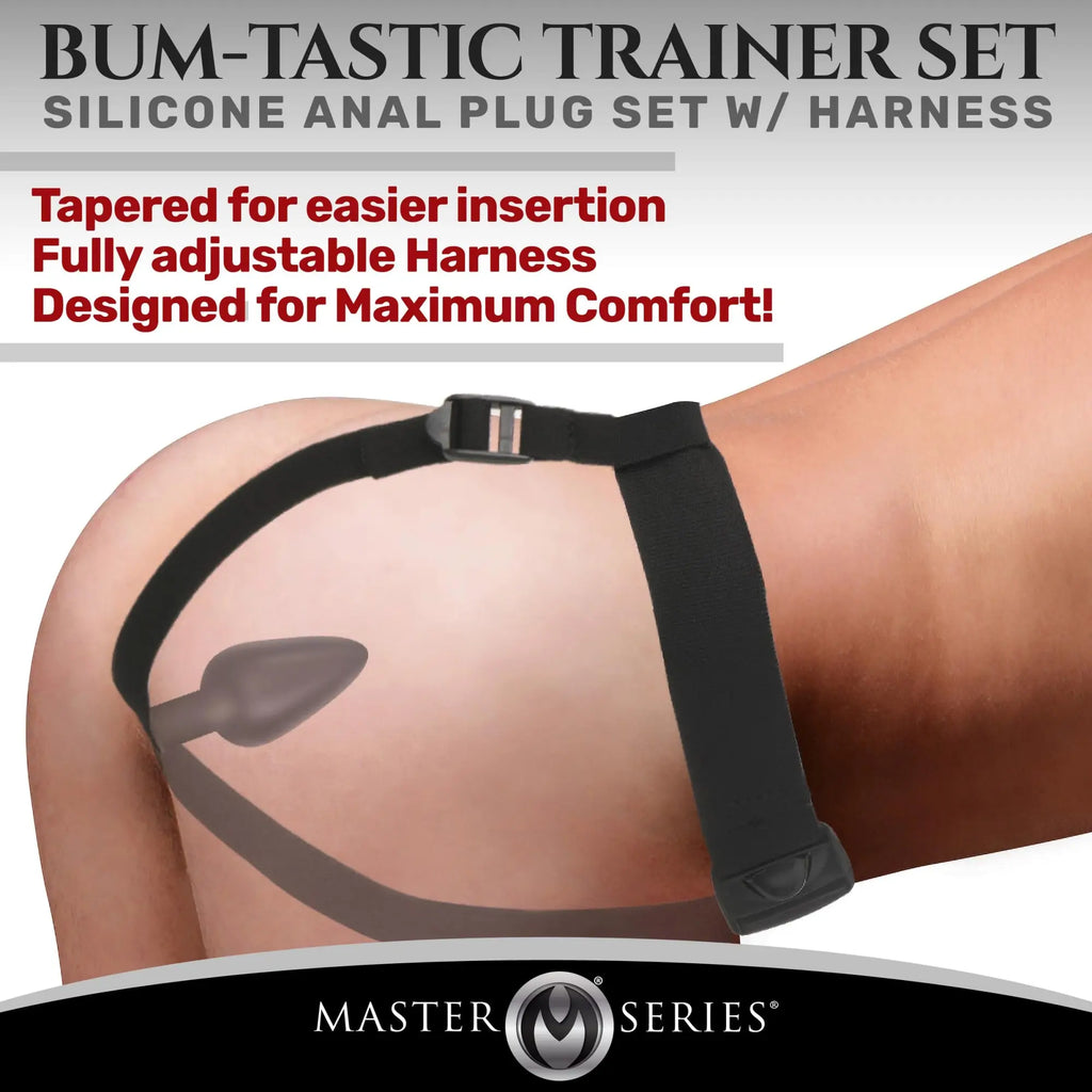 Master Series Bum-Tastic Trainer Set: Black silicone anal plug with an adjustable black harness worn on the body.