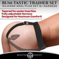 Master Series Bum-Tastic Trainer Set: Black silicone anal plug with an adjustable black harness worn on the body.