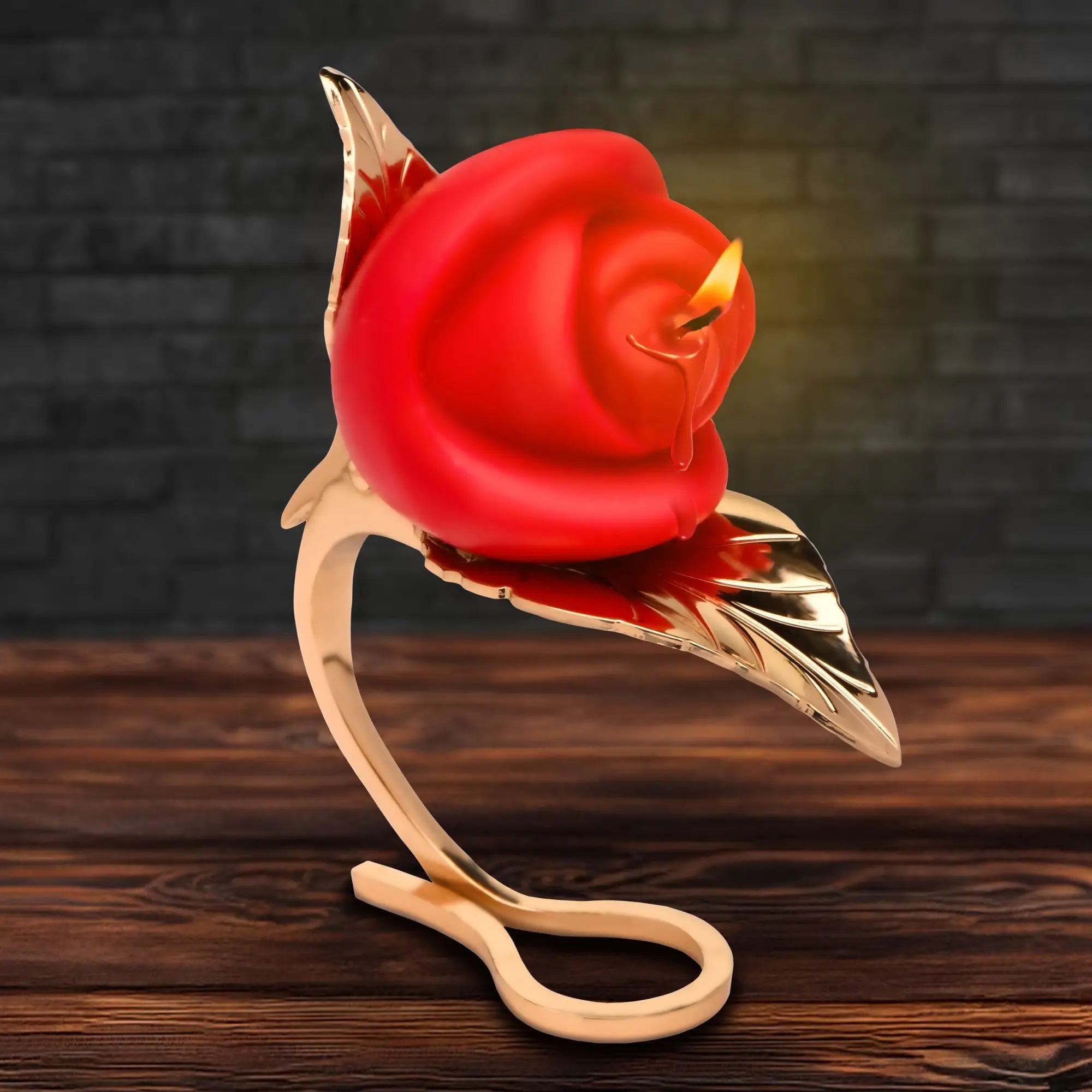 Master Series Burning Passion rose candle in a sleek, gold-colored leaf-shaped metal holder on a wooden surface.