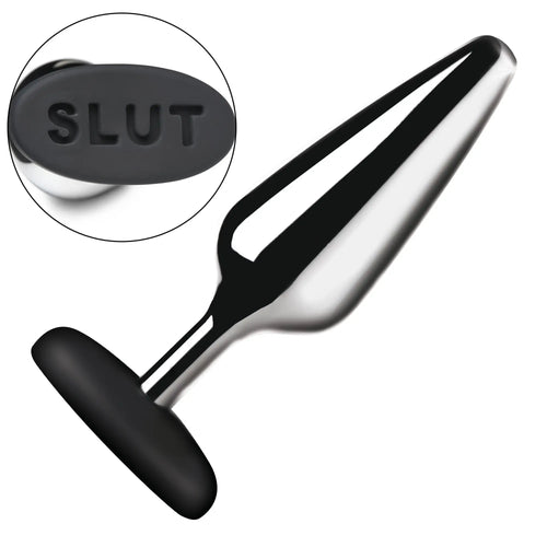 Master Series silver metal butt plug with a black silicone base featuring the debossed text "SLUT" on the end.