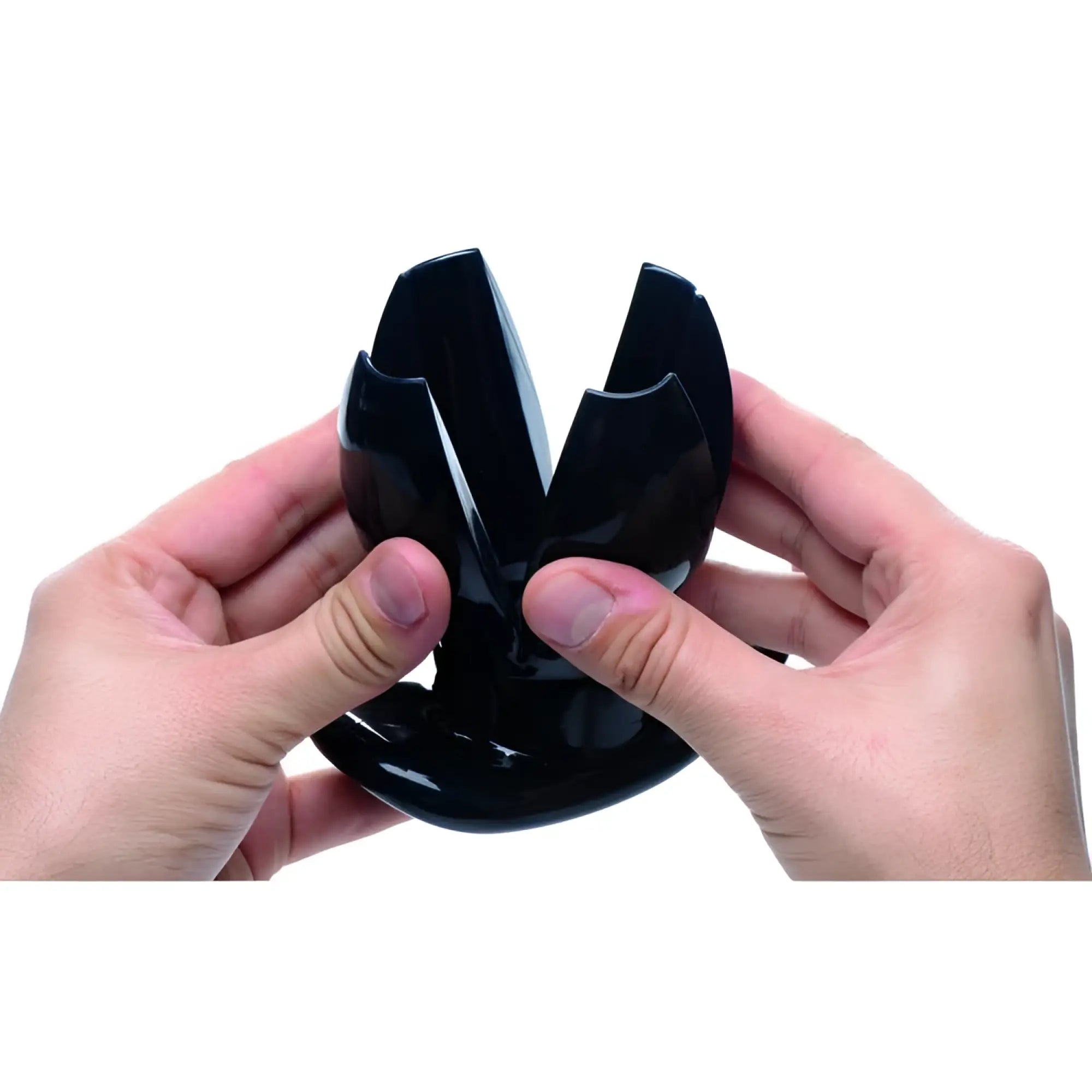 Hands holding a black, claw-style Master Series expanding anal dilator against a white background.