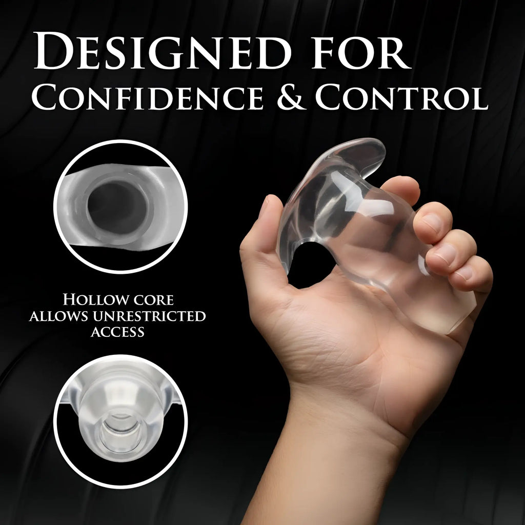 Master Series Clear View Hollow Anal Plug: A transparent, hollow-core silicone plug held in a hand against black.