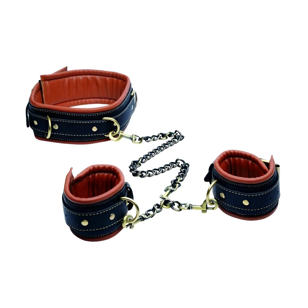 Master Series Coax collar and wrist restraints in black and orange leather with brass hardware and connecting chains.