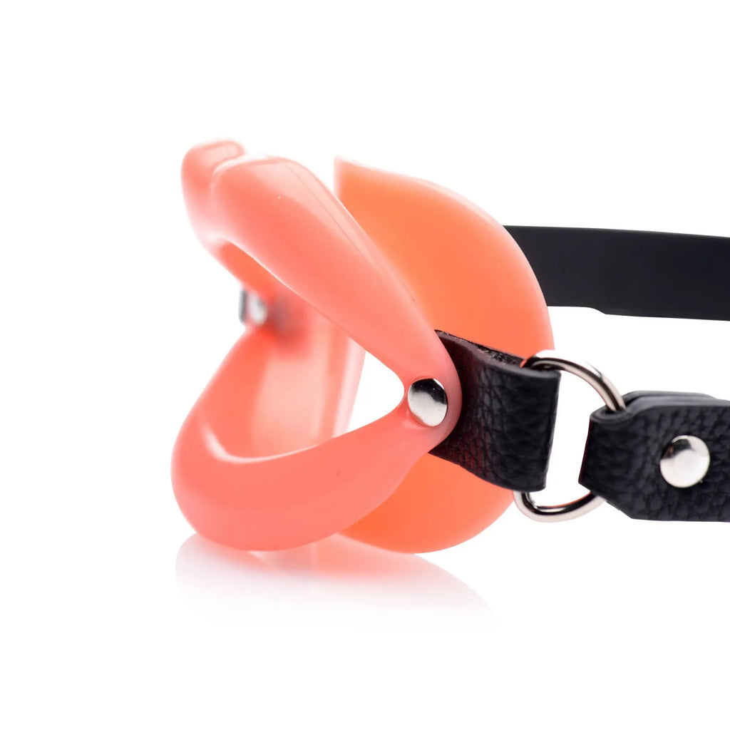 Master Series mouth gag featuring a soft, peach-colored silicone lip-shaped attachment on black leather straps.
