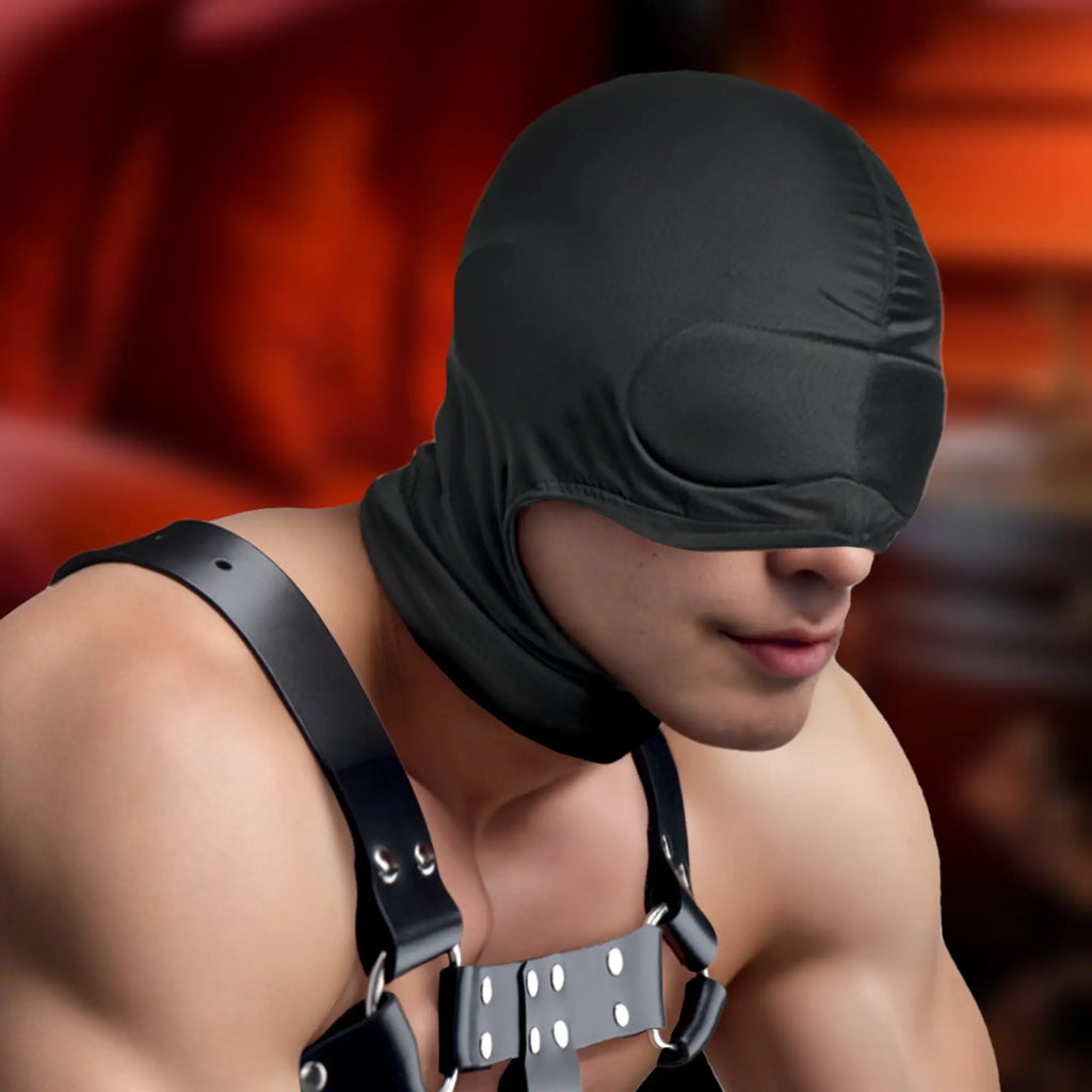Master Series The Cocksucker Hood: A black fabric sensory deprivation hood covering the eyes, worn by a man in harness.
